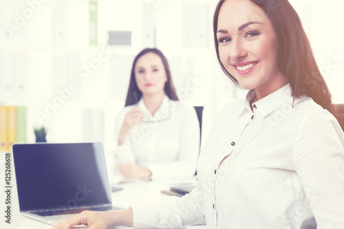 Smiling businesswoman in office with colleague