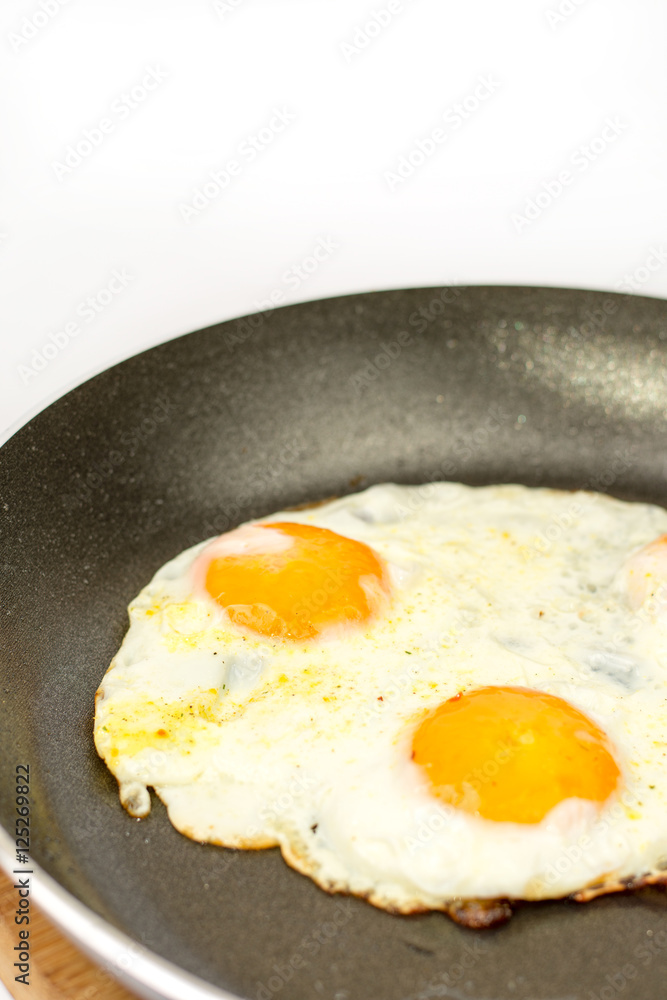 Closeup macro view of fried eggs in teflon frying pan Closeup macro view of fried eggs in teflon frying pan