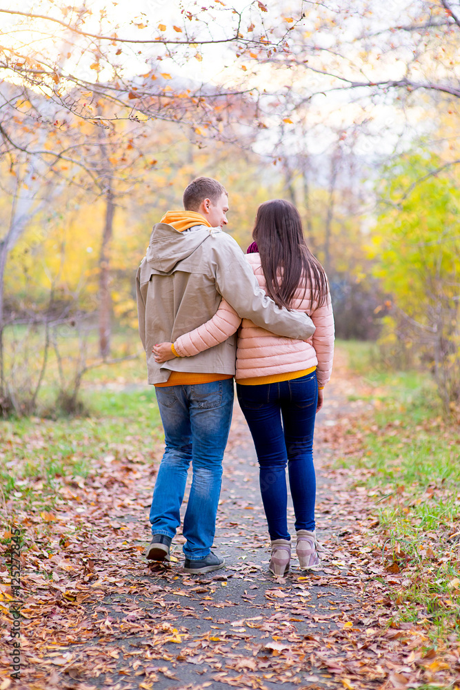 Fototapeta premium smiling couple hugging in autumn park from back