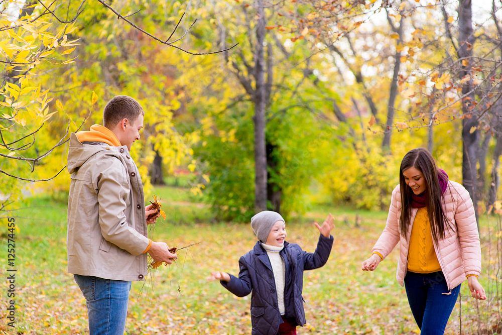 family playing with leaves autumn park