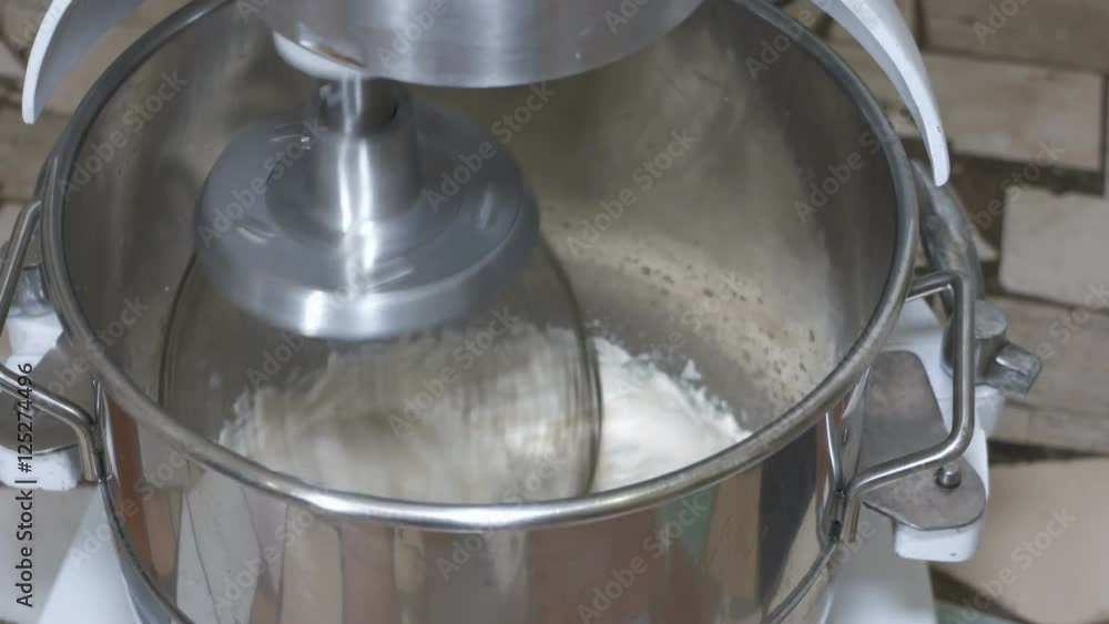 industrial bakery planetary mixer whipping marshmallow mixture in the large mixing bowl at confectionery factory industrial bakery planetary mixer whipping marshmallow mixture in the large mixing bowl at confectionery factory