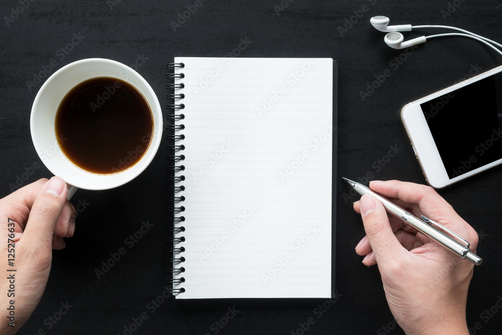 Obraz premium Man is going to write on the notebook. Top view, flat lay.