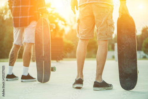 Skaters friends outdoor in urban city with skateboards in their hands