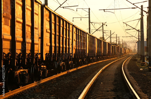 Freight train moving on the tracks at sunset