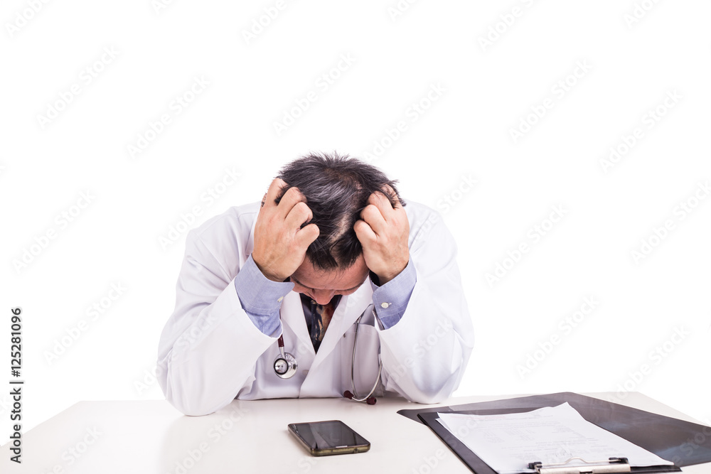 Depressed sad matured Asian doctor seated behind desk Depressed sad matured Asian doctor seated behind desk