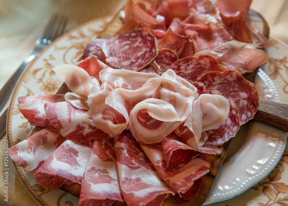 Typical various italian salami, servided on plate at restaurant.