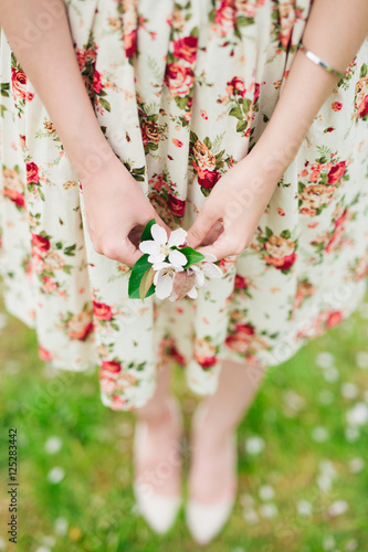 girl in flower dress holding sakura cherry blossom in hands