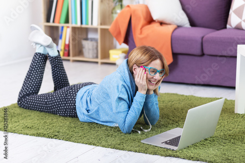 Young woman lying on the floor with lap top computer