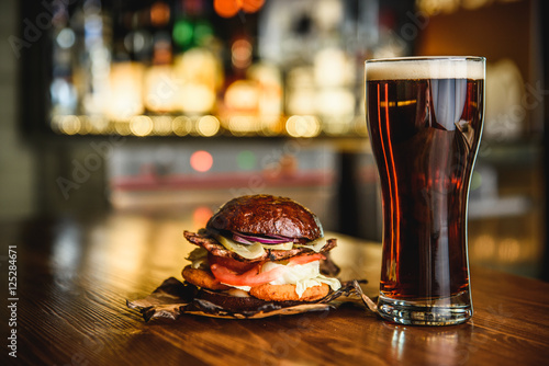 Hamburger and dark beer on a pub background. photo