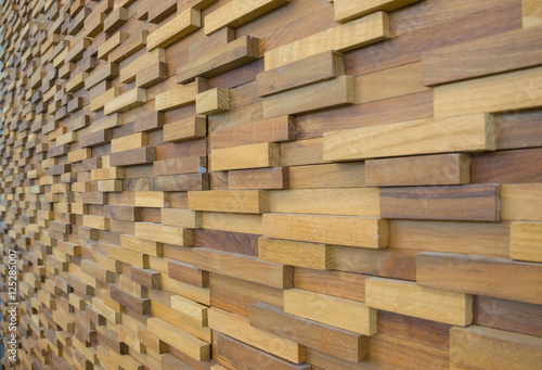 exposed wooden wall exterior  patchwork of raw wood forming a beautiful parquet wood pattern. selected focus 