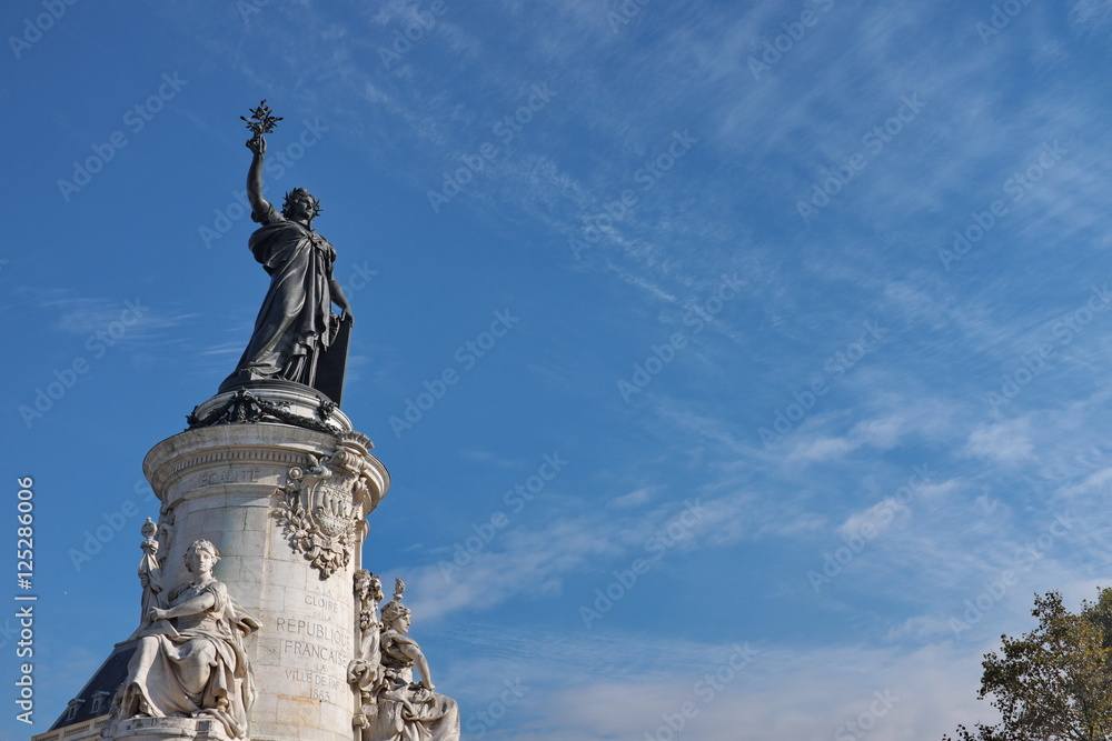 Statue de la République. Place de la République. Socle en pierre blanche. Ciel bleu. Paris, France.