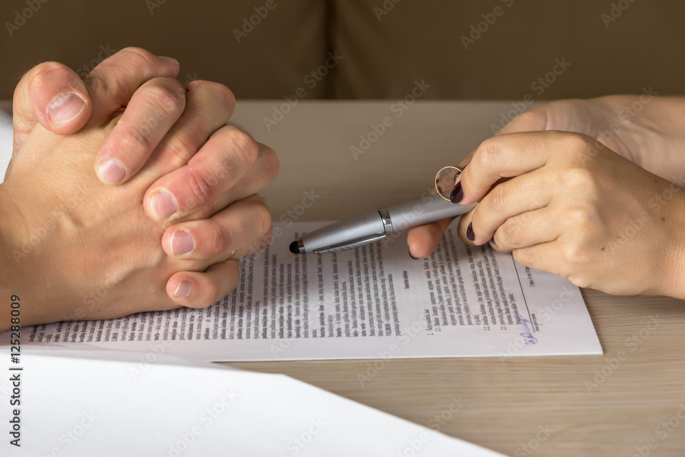 Obraz premium Wife and husband signing divorce documents, woman returning wedding ring