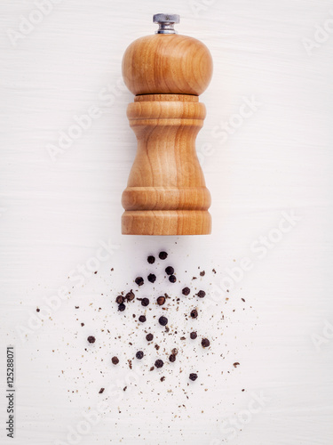 Close up of bottle black pepper mill on white wood table. Season