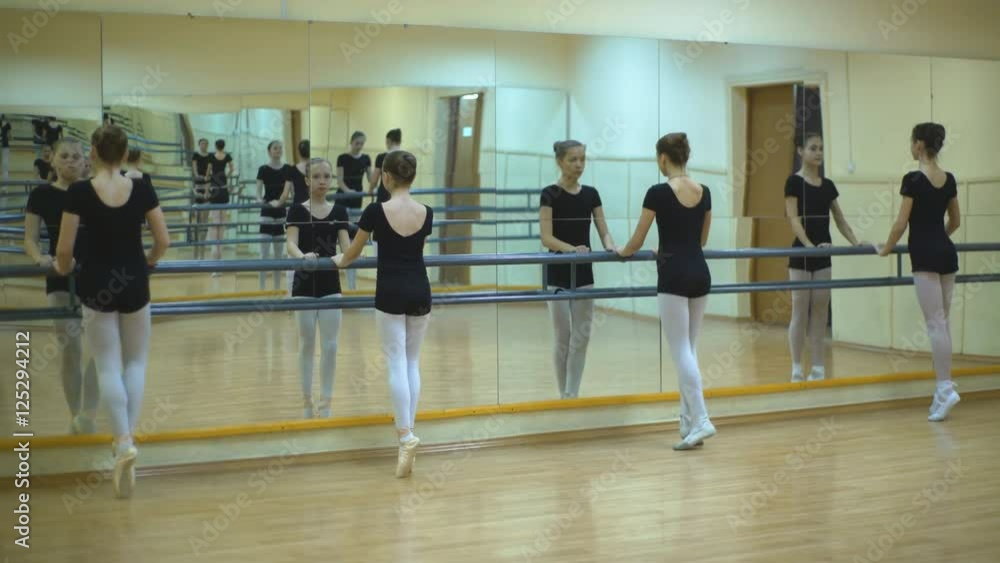 group of four young ballerinas standing in row and practicing ballet group of four young ballerinas standing in row and practicing ballet