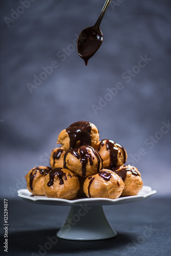 Bilde på lerret Topping profiterole tower with chocolate
