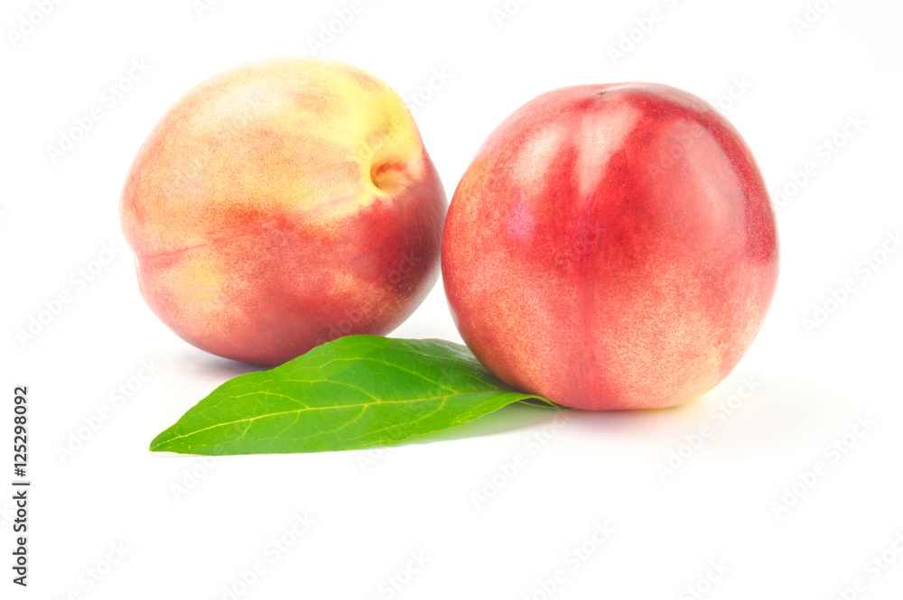 Ripe juicy nectarines with green leaves isolated on white background Ripe juicy nectarines with green leaves isolated on white background