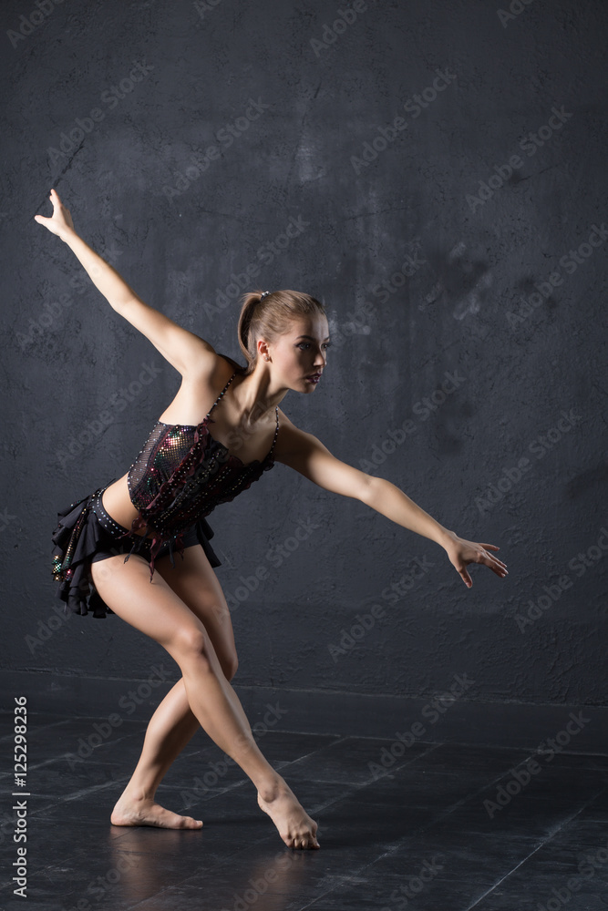 Pretty girl dancing on gray textured wall background Pretty girl dancing on gray textured wall background