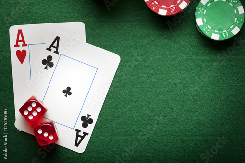 Playing cards, poker chips, and dices on green table