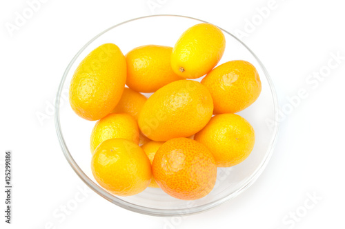 Tasty kumquat in the bowl on white