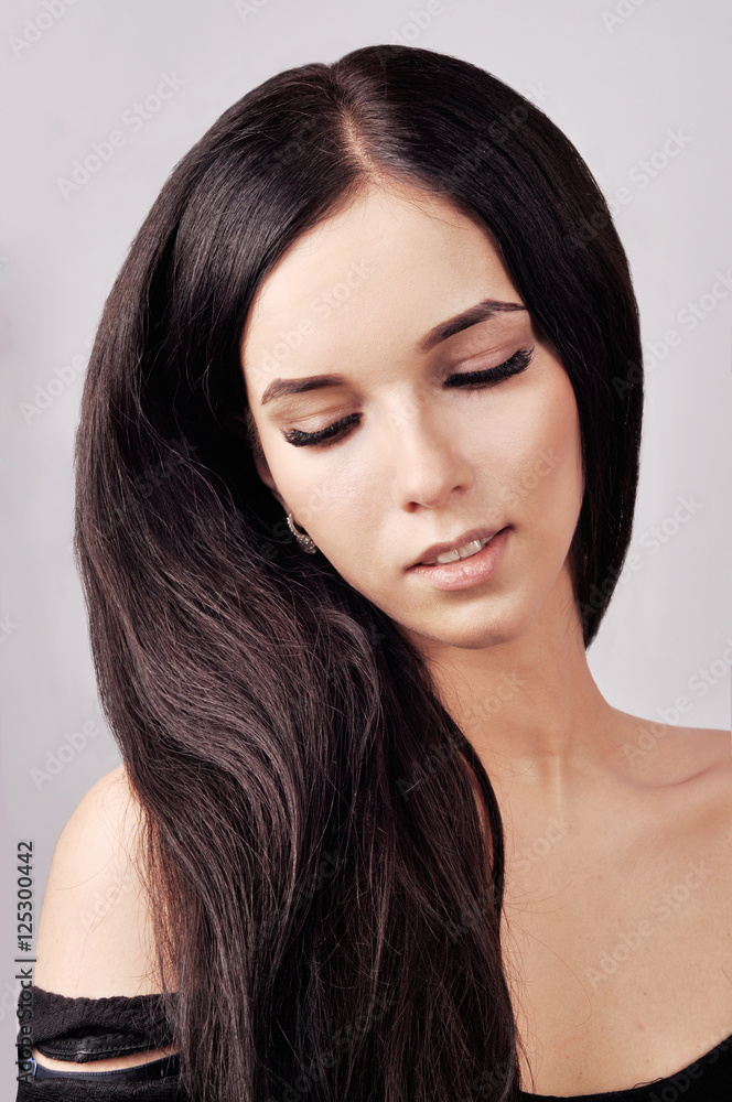 Naklejka premium Portrait of a shy brunette with gorgeous long hair