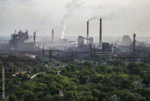 Industrial landscape in Ukraine. Steel factory with smog at sunset. Pipes with smoke. Metallurgical plant. steelworks  iron works. Heavy industry. Ecology problems  atmospheric pollutants.