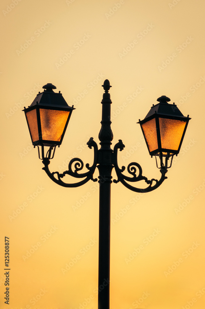 Glowing street lamps/lanterns on a sunset sky