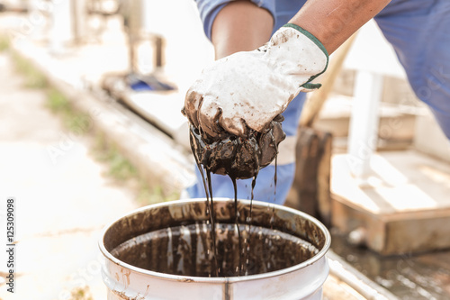 worker cleaning crude oil contaminated on floor. waste management