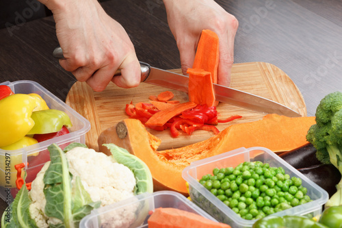 Chef cutting carrot for coo...