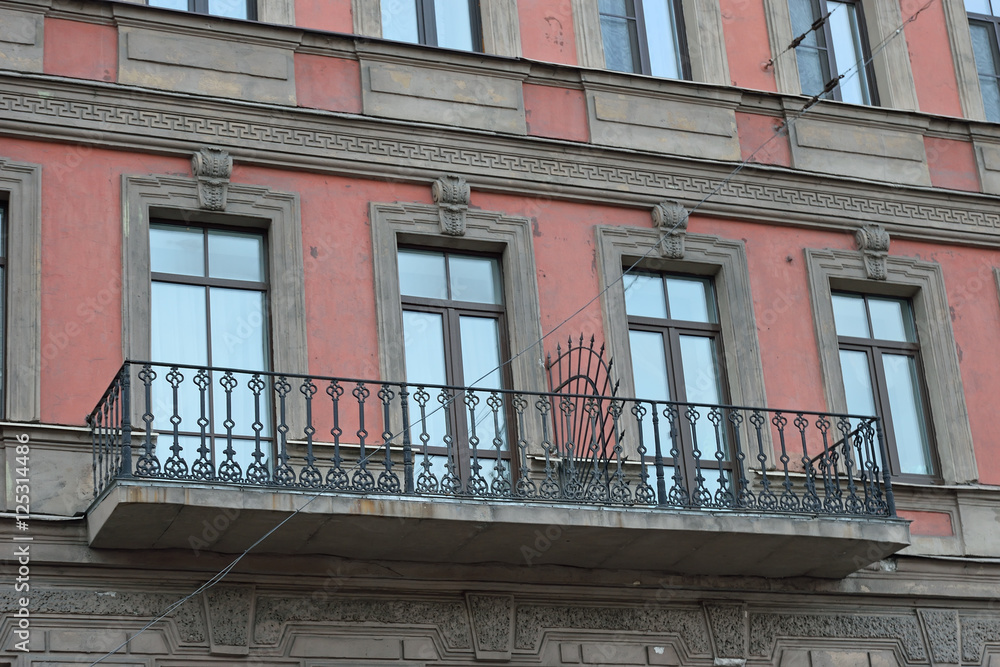 Obraz premium Old balcony with stucco mouldings and bars on the building