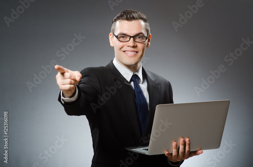 Young businessman with laptop in business concept
