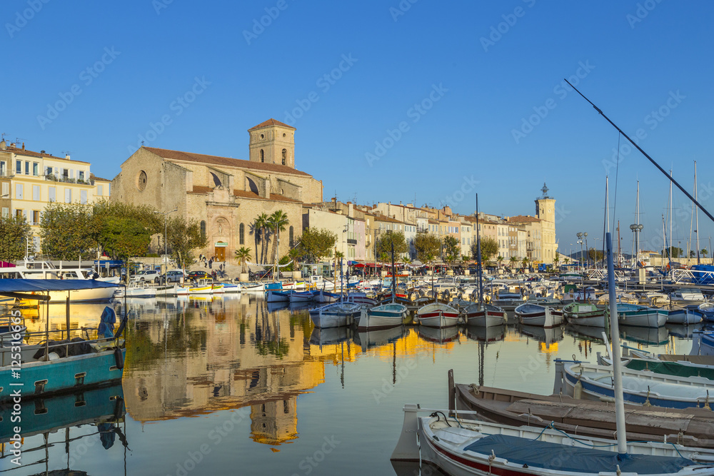 Yachts reflecting in blue water in the old town port of La Ciota