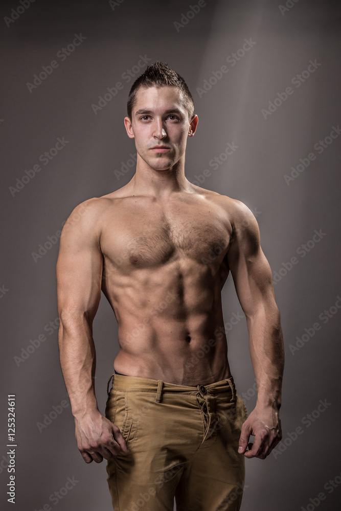 Fototapeta premium young bodybuilder posing strong upper body.