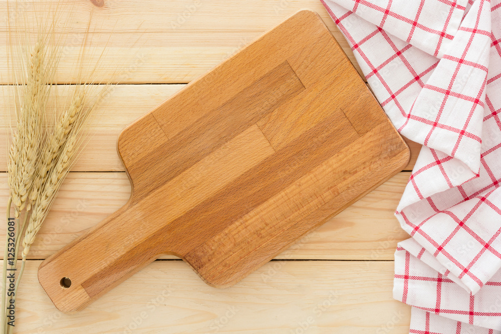 Cutting board, ear of rice paddy and napkin on the wooden background, Top view with blank space and text.