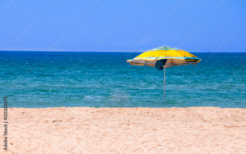 Deserted beach with umbrella
