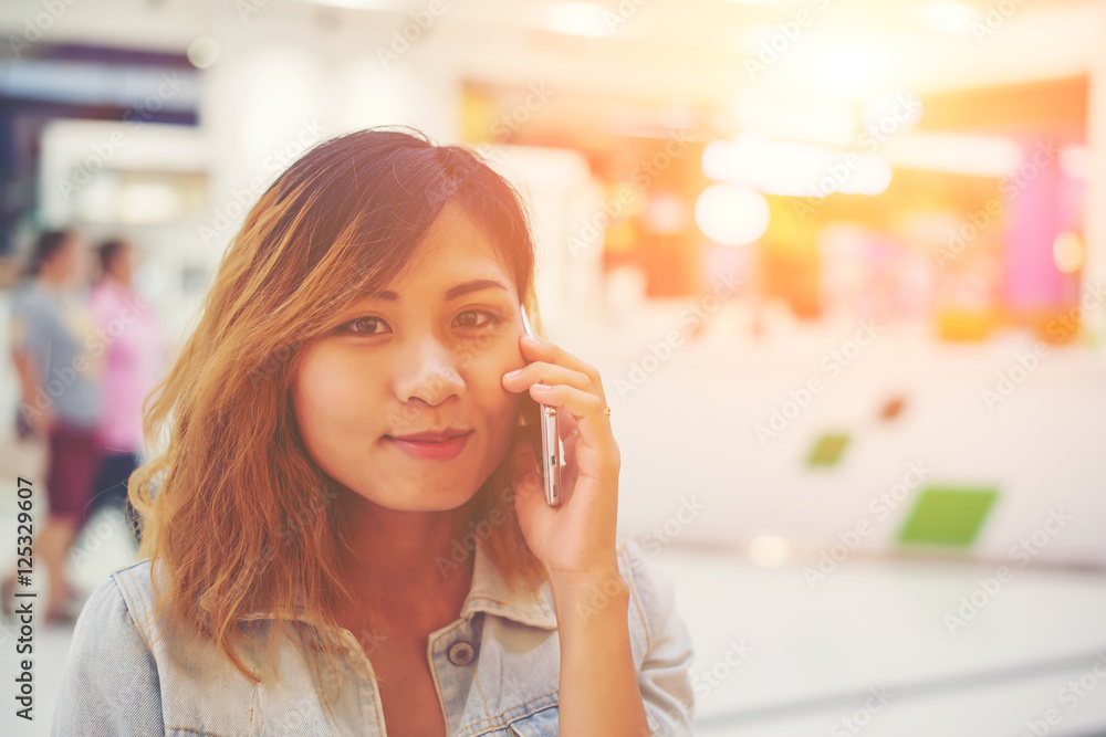 Beautiful young woman talking on the phone in the shopping mall. Beautiful young woman talking on the phone in the shopping mall.