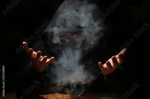 Fotografie, Obraz man in a black hood with cristal ball