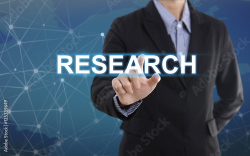 Businessman hand pressing button research. sign on virtual screen. business concept.