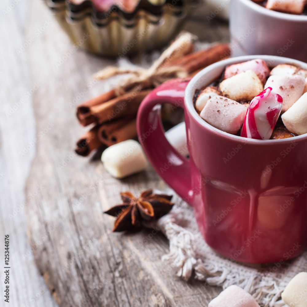 Hot chocolate with marshmallows and spices on rustic wooden table Hot chocolate with marshmallows and spices on rustic wooden table