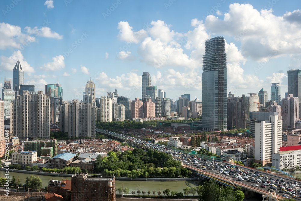 Fototapeta premium shanghai highway overpass with modern city skyline against a sunny sky , China