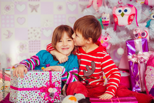 Little brother kisses cheek of his sister