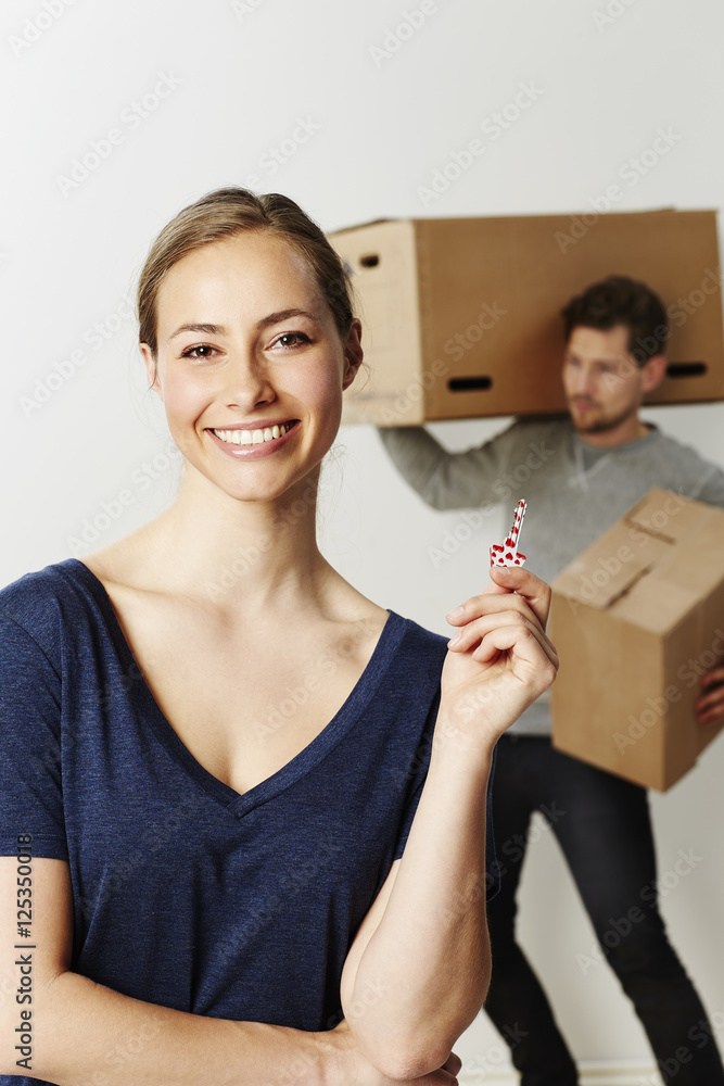 Beautiful woman holding key to new home, portrait Beautiful woman holding key to new home, portrait