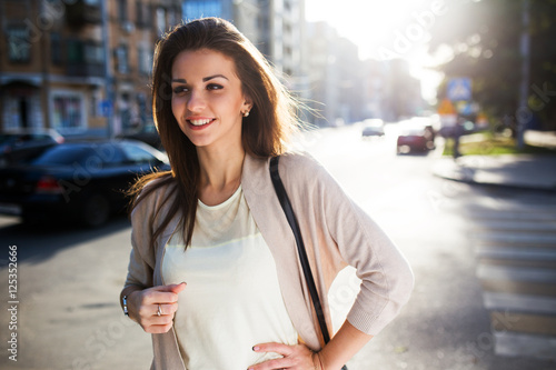 Portrait of beauty woman with perfect smile walking on the street and looking at camera