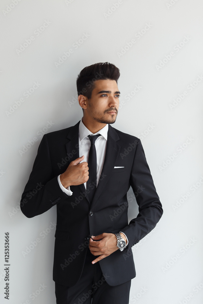 Making business look good. Confident young man in formal wear looking away while standing against grey background Making business look good. Confident young man in formal wear looking away while standing against grey background