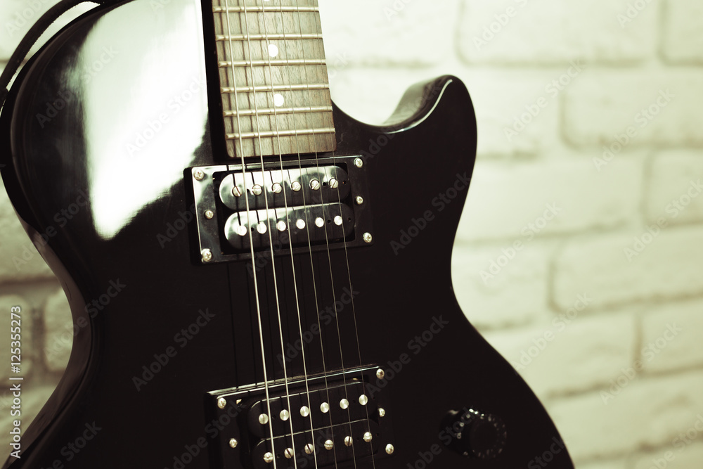 Electric guitar body and neck detail on wooden background Electric guitar body and neck detail on wooden background