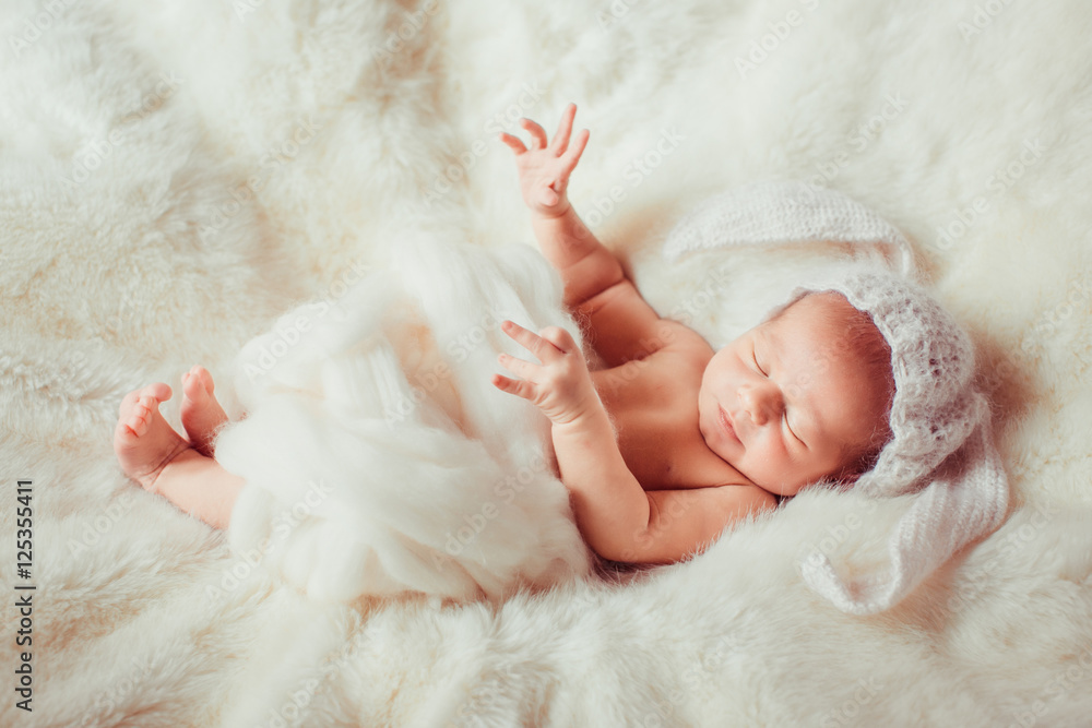 newborn lying on blanket in a white hat rabbit newborn lying on blanket in a white hat rabbit