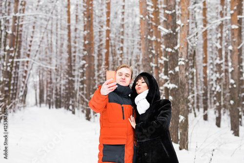 happy couple taking selfie by smartphone in winter © satura_