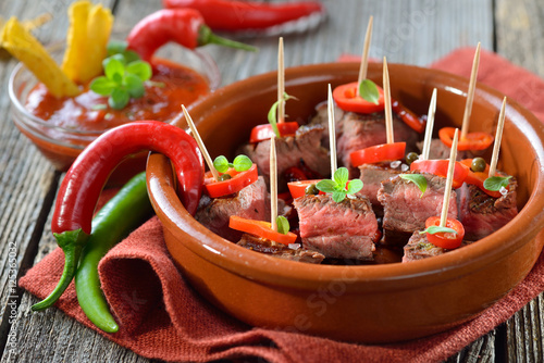 Bild auf Leinwand Pikante Steak-Tapas mit Chili, Paprika und scharfer Dip-Sauce - Hot steak tapas