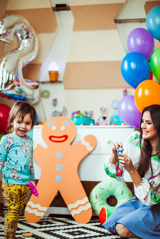 Picture of mom and son playing on the floor in room decorated fo
