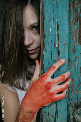 Ghost woman behind vintage wooden door, blood covered hand