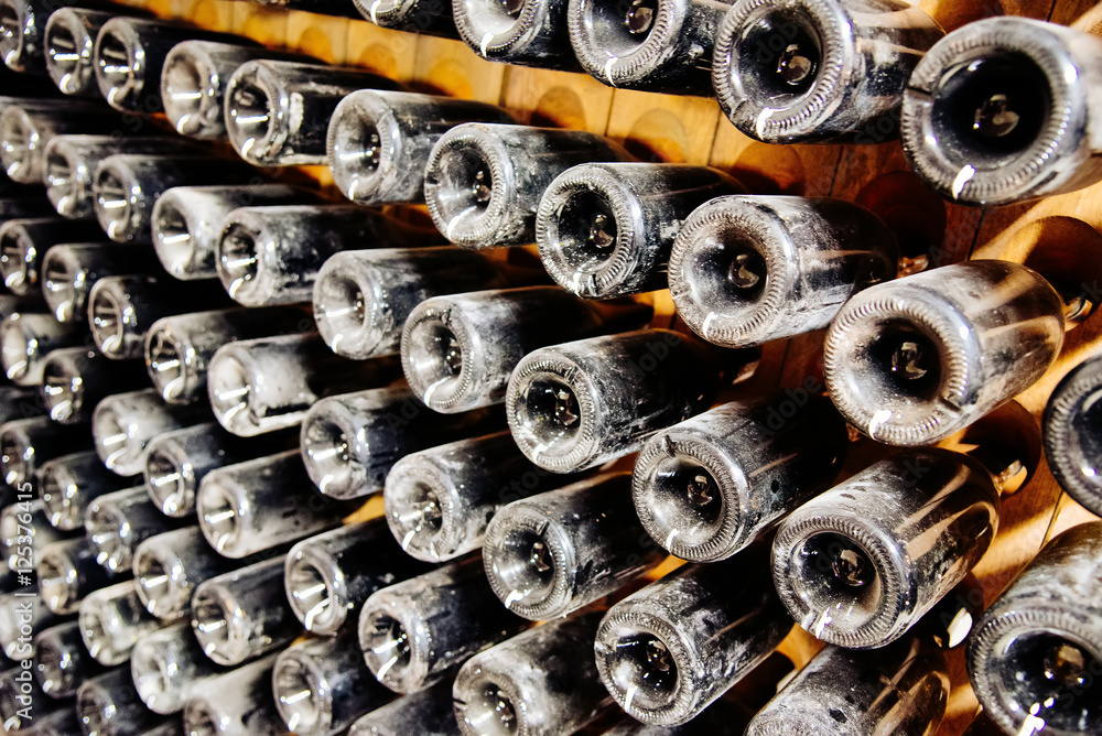 Old and dusty wine bottles in a wine cellar